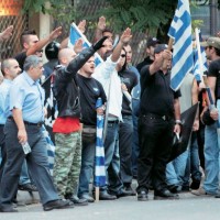 Mέλη της Χρυσής Αυγής χαιρετούν ναζιστικά υπό το βλέμμα του «φύρερ» της οργάνωσης Ν. Μιχαλολιάκου